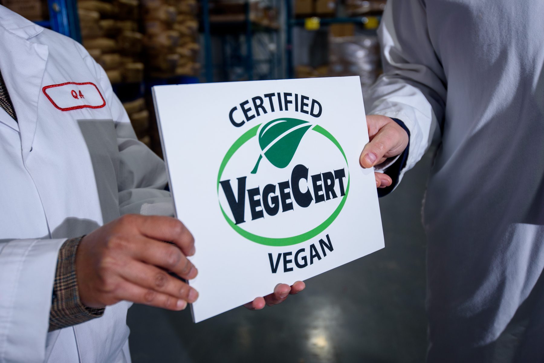 A VegeCert inspector handing over a Certified Vegan seal inside a manufacturing facility